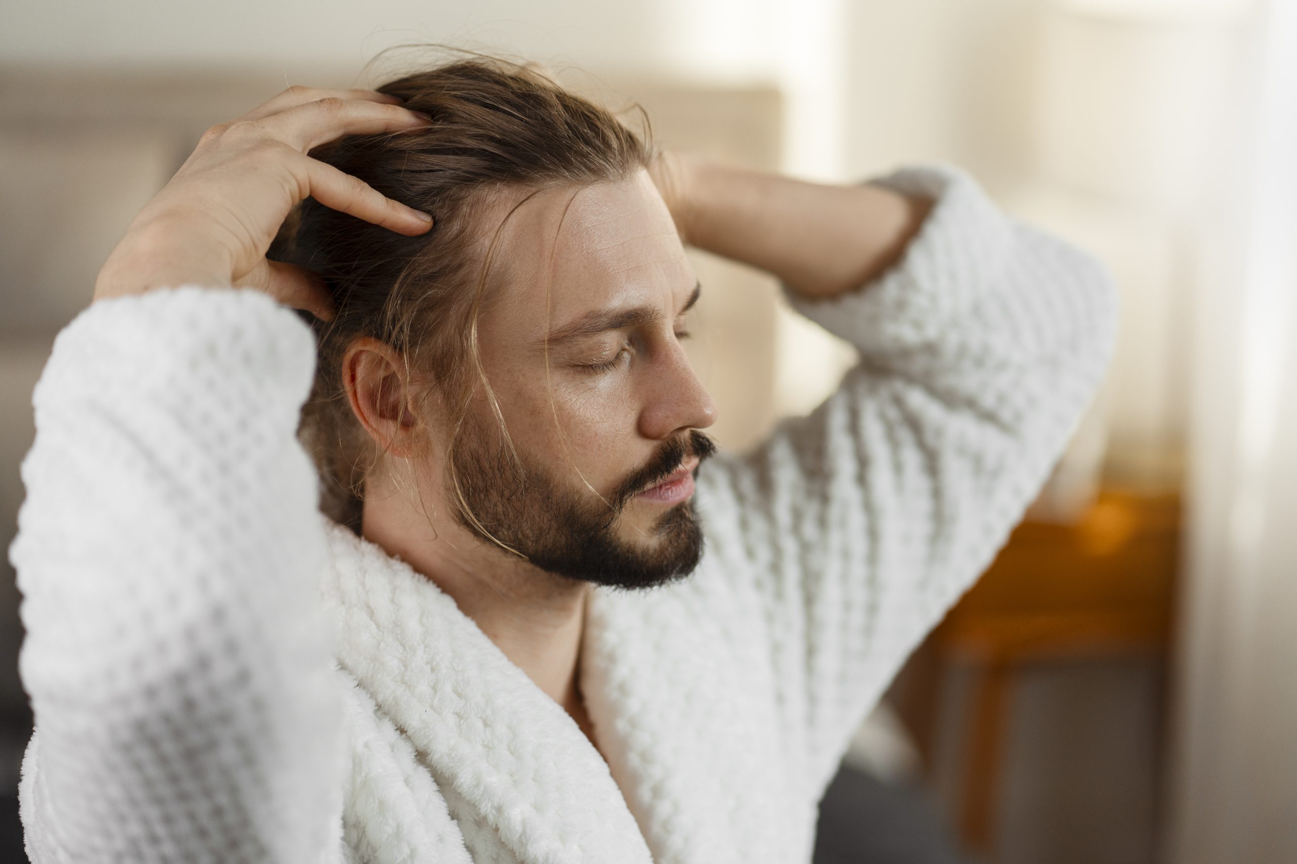 man giving himself scalp massage